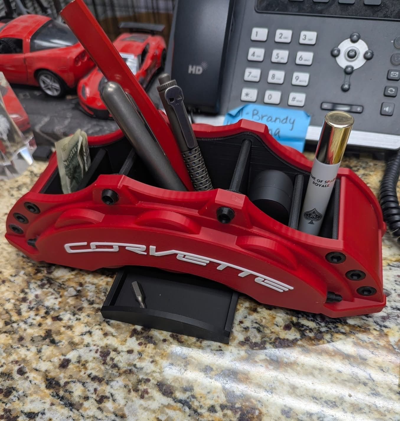 Red Corvette car brake caliper with tools on a countertop