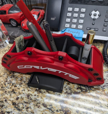 Red Corvette car brake caliper with tools on a countertop